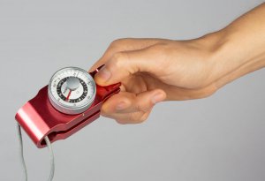 Een hand met een apparaatje tussen de vingers om de kracht te kunnen meten tijdens de cursus hand-polsaandoeningen 